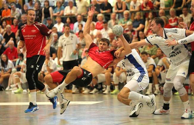 Foto : Torwurf von .... Mads HOXER (Aalborg) gegen Elias KOFLER und Andreas MAGAARD ( HSV ) Handball Herren international, Saisonvorbereitung beim Heide Cup in Schneverdingen am So. 10.08.2025 Endspiel Finale HSV Handball - Aalborg HB 25 - 28