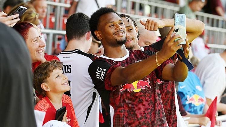Fußball-Bundesliga DFB-Pokal Saison 2025 2026, Training bei Bundesligist RB Leipzig (12.08.2025). Lois Openda (Mittelstuermer RB Leipzig, Rueckennummer 11, 11) (li.) und Xavi Simons (Offensives Mittelfeld RB Leipzig, Rueckennummer 10) mit einem Telefon-Selfie für Fans nach dem Training von RB Leipzig (12.08.2025) Leipzig Sachsen Deutschland Red-Bull-Trainingsgelände am Cottaweg
