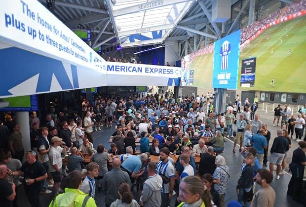 Brighton fans enjoy a drink whilst watching the early match on the big screen in the fan zone terrace area before the Premier League match between Brighton and Hove Albion and Fulham at the American Express Stadium, Brighton UK - 16th August 2025 Brighton v Fulham Premier League Football, Amex Stadium, Sussex, United Kingdom - 16 Aug 2025Brighton Amex Stadium Sussex United Kingdom Editorial use only. No merchandising. For Football images FA and Premier League restrictions apply inc. no internet mobile usage without FAPL license - for details contact Football Dataco  Copyright: xLizxFinlayson Shutterstockx 15443909q