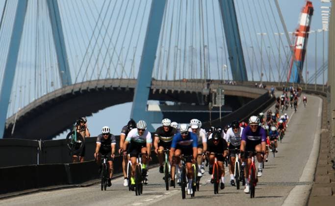 Radrennen ADAC Cyclassics in Hamburg: Teilnehmer und Teilnehmerinnen auf der Jedermann-Strecke über 110 Kilometer überqueren die Köhlbrandbrücke. Ein Teilenehmer (l.) muss sein rad nach einen Sturz allerdings tragen.