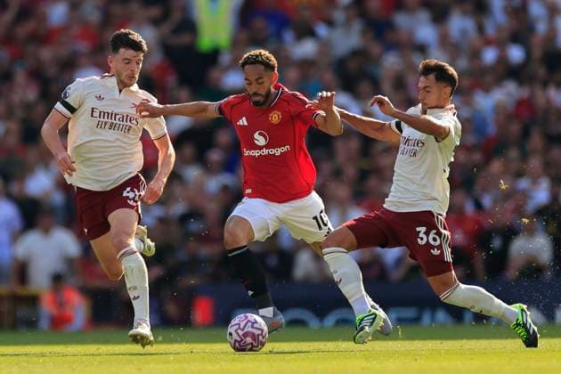 Manchester United, ManU v Arsenal Premier League 17 08 2025. Matheus Cunha (10) of Manchester United runs between Declan Rice (41) and Martin Zubimendi (36) of Arsenal during the Premier League match between Manchester United and Arsenal at Old Trafford, Manchester, England on 17 August 2025. Manchester Old Trafford Greater Manchester England Editorial use only DataCo restrictions apply See www.football-dataco.com , Copyright: xConorxMolloyx PSI-22618-0133