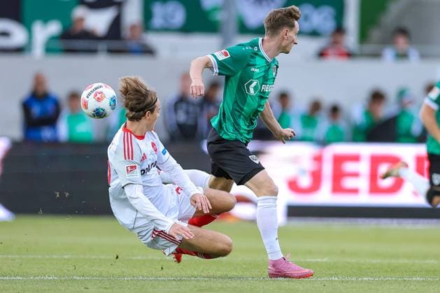 22.08.2025, Fußball, Preußen Münster - 1. FC Nürnberg, 2. Fußball Bundesliga, Preußenstadion, Saison 2025 2026: Caspar Jander (1FC Nuernberg 20) verrutscht beim Zweikampf gegen Joshua Mees (Preussen Muenster 08) die Hosen und zieht dabei halb Blank Popo Popoblitzer DFB regulations prohibit any use of photographs as image sequences and or quasi-video. Nordrhein-Westfalen Deutschland