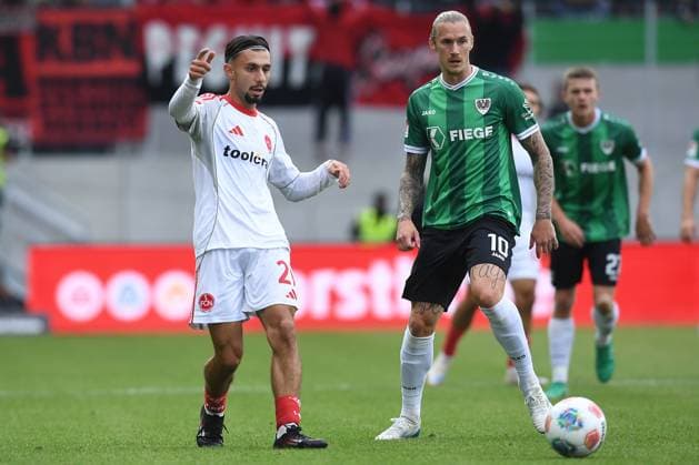 Fußball 2. Bundesliga 3. Spieltag SC Preußen Münster - 1. FC Nürnberg am 22.08.2025 im LVM-Preußenstadion in Münster Berkay Yilmaz ( Nürnberg ), links - Marvin Schulz ( Münster ), rechts DFL regulations prohibit any use of photographs as image sequences and or quasi-video.