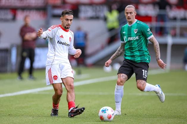 22.08.2025, Fußball, Preußen Münster - 1. FC Nürnberg, 2. Fußball Bundesliga, Preußenstadion, Saison 2025 2026: Berkay Yilmaz (1FC Nuernberg 21) im Zweikampf gegen Marvin Schulz (Preussen Muenster 10) DFB regulations prohibit any use of photographs as image sequences and or quasi-video. Nordrhein-Westfalen Deutschland