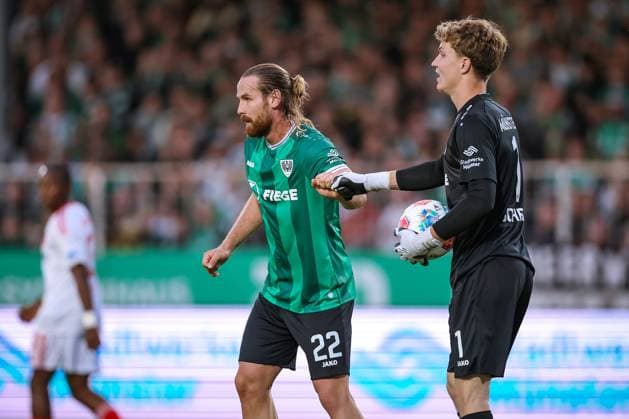 22.08.2025, Fußball, Preußen Münster - 1. FC Nürnberg, 2. Fußball Bundesliga, Preußenstadion, Saison 2025 2026: Jannis Heuer (Preussen Muenster 22) zusammen mit Torwart Johannes Schenk (Preussen Muenster 01) DFB regulations prohibit any use of photographs as image sequences and or quasi-video. Nordrhein-Westfalen Deutschland