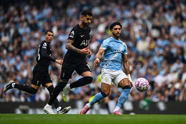 23rd August 2025; Etihad Stadium, Manchester, England; Premier League Football, Manchester City versus Tottenham Hotspur; Cristian Romero of Tottenham Hotspur plays the ball back to his goalkeeper under pressure from Omar Marmoush of Manchester City  GodfreyxPitt