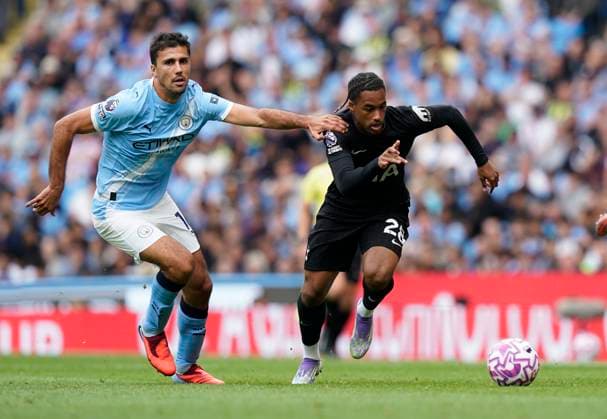 Manchester, England, 23rd August 2025. Wilson Odobert of Tottenham (R) is challenged by Rodri of Manchester City during the Manchester City vs Tottenham Hotspur Premier League match at the Etihad Stadium, Manchester. Picture credit should read: Andrew Yates Sportimage EDITORIAL USE ONLY. No use with unauthorised audio, video, data, fixture lists, club league logos or live services. Online in-match use limited to 120 images, no video emulation. No use in betting, games or single club league player publications. SPI_031_AY_MAN_CITY_SPURS SPI-4081-0031