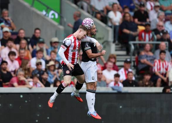 23rd August 2025; Gtech Community Stadium, Brentford, London, England; Premier League Football, Brentford versus Aston Villa; Keane Lewis-Potter of Brentford heads the ball over John McGinn of Aston Villa  JohnxPatrickxFletcher