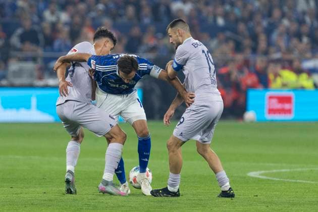 2. Fussball Bundesliga, FC Schalke 04 - VfL Bochum; 23.08.2025 Kenan Karaman (FC Schalke 04, 19) zwischen Matus Bero (VfL Bochum, 19) und Cajetan Lenz (VfL Bochum, 34). 2. Fußball Bundesliga, FC Schalke 04 - VfL Bochum, 3. Spieltag, am 23.08.2025, Veltins-Arena, Gelsenkirchen. DFL regulations prohibit any use of photographs as image sequences and or quasi-video