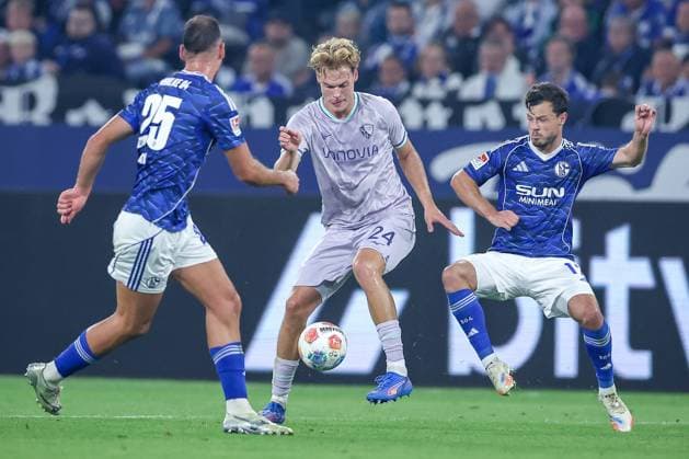 23.08.2025, Fußball, FC Schalke 04 - VfL Bochum, 3.Spieltag, 2. Fußball Bundesliga, Veltins-Arena Gelsenkirchen, Saison 2025 2026: Nikola Katic (Schalke04 25) und Adrian Gantenbein (Schalke04 17) im Zweikampf gegen Mats Pannewig (VfL Bochum 24) DFB regulations prohibit any use of photographs as image sequences and or quasi-video. Nordrhein-Westfalen Deutschland