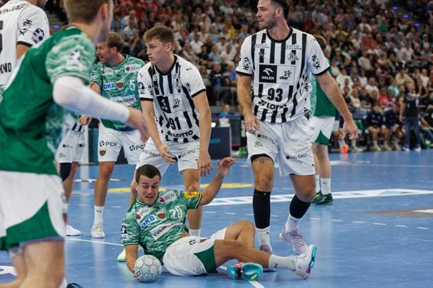 Tim Freihöfer (Füchse Berlin, 20) am Boden, dahinter von links: Bence Imre (THW Kiel, 91), Veron Nacinovic (THW Kiel, 93), 23.08.2025, München (Deutschland), Handball Super Cup der Männer 2025