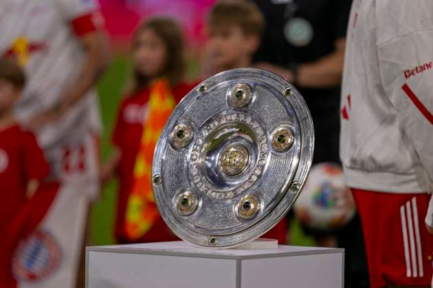 22.08.2025, Fussball Bundesliga 2025 2026, 1.Spieltag, FC Bayern München - RB Leipzig, in der Allianz-Arena München, Die Meisterschale steht auf der Stele, die Mannschaften stehen dahinter bereit