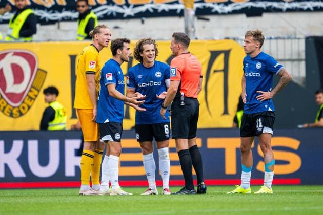 24.08.2025 - Fußball, 2025 2026, 2. Bundesliga, 3. Spieltag, DSC Arminia Bielefeld - SG Dynamo Dresden: (L-R) Vinko Sapina (Dresden), Christopher Lannert (Bielefeld), Mael Corboz (Bielefeld), Tom Bauer (Schiedsrichter), Joel Grodowski (Bielefeld) nach dem Videobeweis DFL REGULATIONS PROHIBIT ANY USE OF PHOTOGRAPHS AS IMAGE SEQUENCES AND OR QUASI-VIDEO.