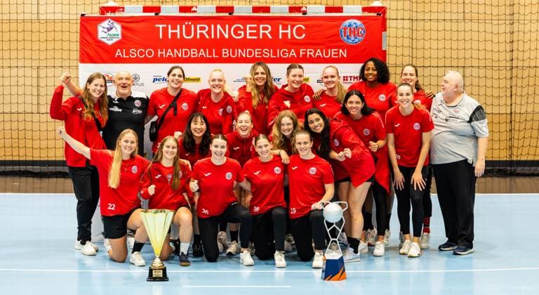 28.08.2025, GER, Handball, Frauen, Saison 2025 2026, Alsco 1.Bundesliga, Thueringer HC Saisoneröffnung öffentliches Training Mannschaftspraesentation zeigt die Mannschaft des Thueringer HC mit den beiden Pokalen des EHF European Cup und dem DHB-Super Cup, Julie Holm (Thueringer HC,8) Herbert Mueller (Thueringer HC,Trainer) Josefine Hanfland (Thueringer HC,57) Johanna Reichert (Thueringer HC,29) Anika Niederwieser (Thueringer HC,14) Kim Ott (Thueringer HC,25) Laura Kuske (Thueringer HC,11) Sharon Nooitmeer (Thueringer HC,3) Csenge Kuczora (Thueringer HC,59) Helfried Mueller (Thueringer HC,Co-Trainer) Rikke Hoffbeck Petersen (Thueringer HC,22) Natsuki Aizawa (Thueringer HC,23) Nathalie Hendrikse (Thueringer HC,6) Christina Loevgren Hallberg (Thueringer HC,1) Giulia Guarieiro (Thueringer HC,13) Jana Scheib (Thueringer HC,20) Maria Galic (Thueringer HC, Sportsphysiotherapeutin) Anna Szabo (Thueringer HC,26) Dilayla Alarslan (Thueringer HC,38) Luca Farago (Thueringer HC,19) 99947 Bad Langensalza Salza Halle Sporthalle Mehrz Thüringen Deutschland