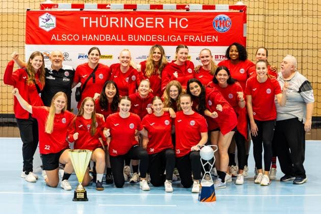 28.08.2025, GER, Handball, Frauen, Saison 2025 2026, Alsco 1.Bundesliga, Thueringer HC Saisoneröffnung öffentliches Training Mannschaftspraesentation zeigt die Mannschaft des Thueringer HC mit den beiden Pokalen des EHF European Cup und dem DHB-Super Cup, Julie Holm (Thueringer HC,8) Herbert Mueller (Thueringer HC,Trainer) Josefine Hanfland (Thueringer HC,57) Johanna Reichert (Thueringer HC,29) Anika Niederwieser (Thueringer HC,14) Kim Ott (Thueringer HC,25) Laura Kuske (Thueringer HC,11) Sharon Nooitmeer (Thueringer HC,3) Csenge Kuczora (Thueringer HC,59) Helfried Mueller (Thueringer HC,Co-Trainer) Rikke Hoffbeck Petersen (Thueringer HC,22) Natsuki Aizawa (Thueringer HC,23) Nathalie Hendrikse (Thueringer HC,6) Christina Loevgren Hallberg (Thueringer HC,1) Giulia Guarieiro (Thueringer HC,13) Jana Scheib (Thueringer HC,20) Maria Galic (Thueringer HC, Sportsphysiotherapeutin) Anna Szabo (Thueringer HC,26) Dilayla Alarslan (Thueringer HC,38) Luca Farago (Thueringer HC,19) 99947 Bad Langensalza Salza Halle Sporthalle Mehrz Thüringen Deutschland