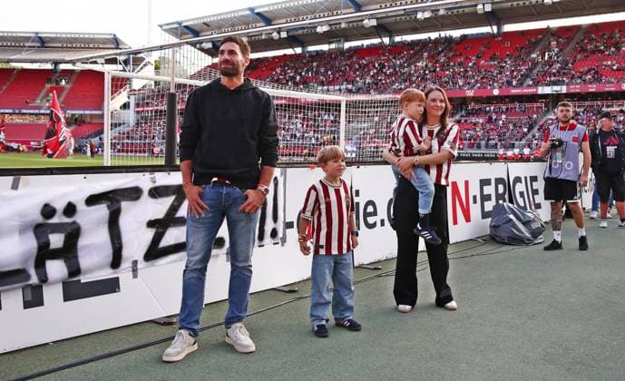 29.08.2025, xmohx, Fussball 2.Bundesliga, 1. FC Nuernberg - SC Paderborn 07 v.l. Ex-Nürnberg Spieler Enrico Valentini bekommt von den Fans eine Choreographie (Nürnberg Fans) geschenkt, steht mit seiner Familie davor, daneben, hintendran, macht Bilder mit seinem Smartphone und seine Frau macht auch Bilder (DFL DFB REGULATIONS PROHIBIT ANY USE OF PHOTOGRAPHS as IMAGE SEQUENCES and or QUASI-VIDEO) Nuernberg