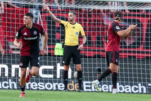 Referee Schiedsrichter Michael Bacher erkennt einen Strafstross durch den VAR ab und revidiert eine rote Karte fuer Tim Janisch 32 (1FC Nuernberg), die Nuernberger Spieler Semir Telalovic 9 (1FC Nuernberg) und Fabio Gruber 4 (1FC Nuernberg) freuen sich, 1. FC Nuernberg vs. SC Paderborn 07, DFL, 2. Bundesliga, Saison 2025 2026, Max-Morlock-Stadion, 4. Spieltag, Hinrunde, 29.08.2025 DFB regulations prohibit any use of photographs as image sequences and or quasi-video Nuernberg Bayern Deutschland