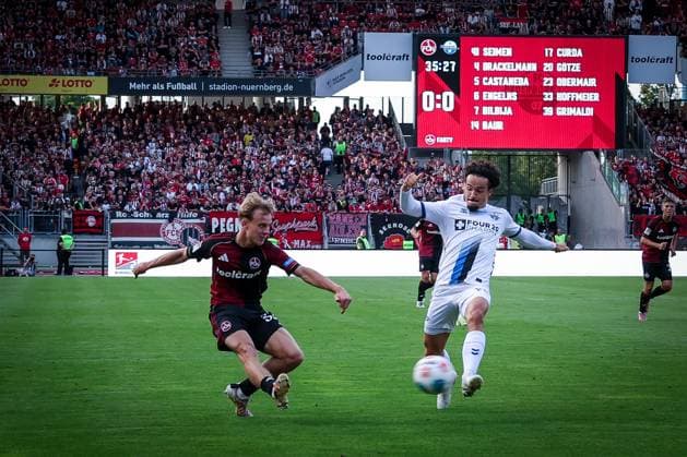 links nach rechts: Tim Janisch 32 (1FC Nuernberg) mit einer Flanke, die Mika Baur 14 (SC Paderborn 07) nicht verhindern kann, 1. FC Nuernberg vs. SC Paderborn 07, DFL, 2. Bundesliga, Saison 2025 2026, Max-Morlock-Stadion, 4. Spieltag, Hinrunde, 29.08.2025 DFB regulations prohibit any use of photographs as image sequences and or quasi-video Nuernberg Bayern Deutschland