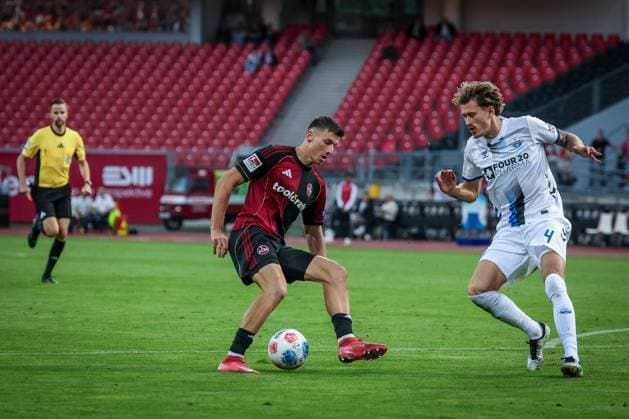 links nach rechts: Referee Schiedsrichter Michael Bacher schaut der Aktion zwischen Semir Telalovic 9 (1FC Nuernberg) und Calvin Brackelmann 4 (SC Paderborn 07) zu, 1. FC Nuernberg vs. SC Paderborn 07, DFL, 2. Bundesliga, Saison 2025 2026, Max-Morlock-Stadion, 4. Spieltag, Hinrunde, 29.08.2025 DFB regulations prohibit any use of photographs as image sequences and or quasi-video Nuernberg Bayern Deutschland