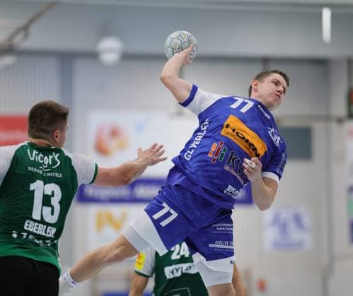 Deutschland - Kelkheim - Münster - 30.08.2025 Handball - Hessen - 3. Liga - Staffel Süd-West - Herren Saison 2025 2026 (2. Spieltag) TSG Münster (blau) - HG Saarlouis (grün) v.l. Sven Eberlein (HG Saarlouis - 13), Lars Zelser (TSG Münster - 77) TSG Münster - HG Saarlouis