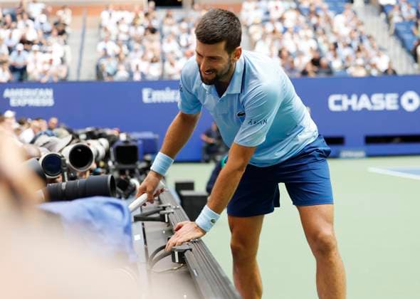 Novak Djokovic of Serbia runs into the photographers area after chasing a ball from Carlos Alcaraz of Spain in a Men s semifinal match at the 2025 US Open Tennis Championship at the USTA Billie Jean King National Tennis Center in New York City on Friday, September 5, 2025.  NYP20250905923 JOHNxANGELILLO