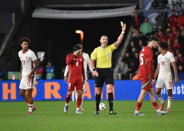 9th September 2025; Swansea.com Stadium, Swansea, Wales; Friendly International Football, Wales versus Canada; Charlie Crew of Wales receives a yellow card from referee, Robert Jones for a late challenge  AledxHopkins
