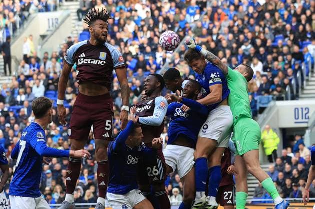 13th September 2025; Hill Dickinson Stadium, Liverpool, England; Premier League Football, Everton versus Aston Villa; Everton goalkeeper Jordan Pickford leaps to punch a clearance under pressure from Tyrone Mings of Aston Villa  DavidxBlunsden