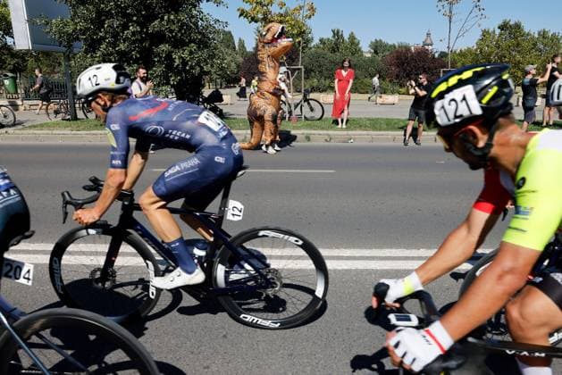 (250915) -- ROMANIA, Sept. 15, 2025 -- A supporter dressed as dinosaur holds his child while cheering for cyclists during the last stage of Tour of Romania 2025 cycling race in Bucharest, Romania, Sept. 14, 2025. (Photo by Xinhua) (SP)ROMANIA-BUCHAREST-CYCLING TOUR OF ROMANIA CristianxCristel 