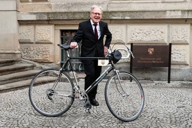 Gustav-Adolf Täve Schur steht mit einem Rennrad vor der Staatskanzlei. Gustav-Adolf Täve Schur, der 94-jährige frühere Radsportler wird für seine Verdienste um den für sein motivierendes Engagement zur Förderung des Nachwuchses und für seine bis heute bestehende Vorbildwirkung geehrt. Er gewann unter anderem 1955 und 1959 die Internationale Friedensfahrt sowie 1958 und 1959 die Straßenweltmeisterschaft der Amateure. Bis heute ist er ein beharrlicher Motivator für Bewegung, gesunde Ernährung und Gemeinsinn. Ministerpräsident Dr. Reiner Haseloff (CDU, Sachsen-Anhalt) hat am Mittwoch, 17. September 2025, in der Magdeburger Staatskanzlei den Verdienstorden des Landes Sachsen-Anhalt an eine Bürgerin und sechs Bürger überreichen.