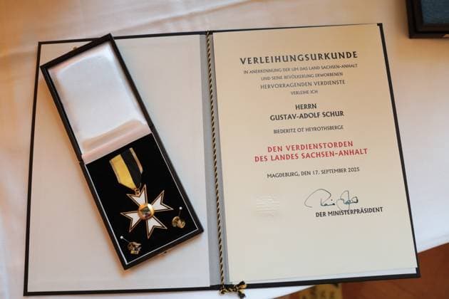 Gustav-Adolf Täve Schur seine Urkunde mit Verdienstorden in der Staatskanzlei. Gustav-Adolf Täve Schur, der 94-jährige frühere Radsportler wird für seine Verdienste um den für sein motivierendes Engagement zur Förderung des Nachwuchses und für seine bis heute bestehende Vorbildwirkung geehrt. Er gewann unter anderem 1955 und 1959 die Internationale Friedensfahrt sowie 1958 und 1959 die Straßenweltmeisterschaft der Amateure. Bis heute ist er ein beharrlicher Motivator für Bewegung, gesunde Ernährung und Gemeinsinn. Ministerpräsident Dr. Reiner Haseloff (CDU, Sachsen-Anhalt) hat am Mittwoch, 17. September 2025, in der Magdeburger Staatskanzlei den Verdienstorden des Landes Sachsen-Anhalt an eine Bürgerin und sechs Bürger überreichen.