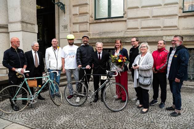 Gustav-Adolf Täve Schur wird von Eva von Angern begrüsst und anderen Menschen vor der Staatskanzlei begrüsst. Gustav-Adolf Täve Schur, der 94-jährige frühere Radsportler wird für seine Verdienste um den für sein motivierendes Engagement zur Förderung des Nachwuchses und für seine bis heute bestehende Vorbildwirkung geehrt. Er gewann unter anderem 1955 und 1959 die Internationale Friedensfahrt sowie 1958 und 1959 die Straßenweltmeisterschaft der Amateure. Bis heute ist er ein beharrlicher Motivator für Bewegung, gesunde Ernährung und Gemeinsinn. Ministerpräsident Dr. Reiner Haseloff (CDU, Sachsen-Anhalt) hat am Mittwoch, 17. September 2025, in der Magdeburger Staatskanzlei den Verdienstorden des Landes Sachsen-Anhalt an eine Bürgerin und sechs Bürger überreichen.