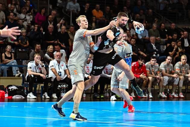 18.09.2025, xlakx, Handball, EHF Champions League, Fuechse Berlin - Aalborg Handbold v.l. Buster Juul (Aalborg Handbold),Fabian Wiede (Fuechse Berlin) Zweikampf, Duell, Kampf, tackle Berlin
