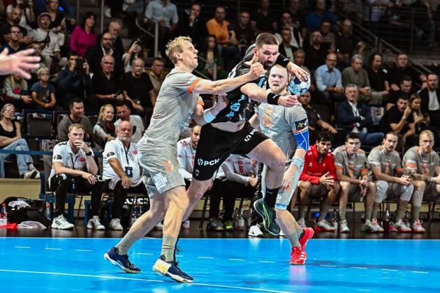 18.09.2025, xlakx, Handball, EHF Champions League, Fuechse Berlin - Aalborg Handbold v.l. Buster Juul (Aalborg Handbold),Fabian Wiede (Fuechse Berlin)Zweikampf, Duell, Kampf, tackle Berlin