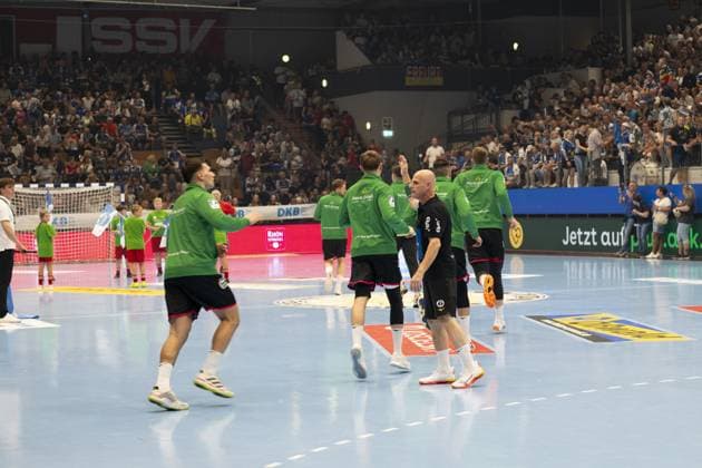 Mehrere Spieler der HSG Wetzlar in grünen Aufwärmtrikots laufen auf das Spielfeld in der Werner-Assmann Halle in Eisenach. DAIKIN Handball: ThSV-Eisenach gegen HSG Wetzlar 20.09.2025 Copyright: xJoshuaxHildebrandtx