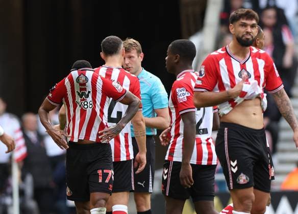 Sunderland, England, 21st September 2025. Reinildo Mandava (L) of Sunderland sent off by referee Sam Barrott during the Sunderland vs Aston Villa Premier League match at the Stadium Of Light, Sunderland. Picture credit should read: Nigel Roddis Sportimage EDITORIAL USE ONLY. No use with unauthorised audio, video, data, fixture lists, club league logos or live services. Online in-match use limited to 120 images, no video emulation. No use in betting, games or single club league player publications. SPI_011_NR_NEWC_ASTO SPI-4153-0011