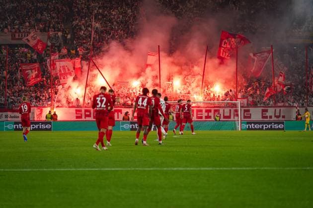 Fussball: UEFA Europa League 2025 26, 1. Spieltag - SC Freiburg vs FC Basel - Europa-Park-Stadion (Freiburg): SC Freiburg Fans mit Pyrotechnik und Fahnen im Hintergrund, Spieler des Club Freiburg im Vordergrund, emotionale Stimmung, Europa League Atmosphäre, Fankultur, Leidenschaft, UEFA-Wettbewerb. Freiburg im Breisgau Baden-Württemberg Deutschland Copyright: xJOERANxSTEINSIEKx