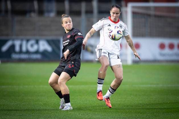 Frauen Fußball-Bundesliga; Bayer 04 Leverkusen - Eintracht Frankfurt, 25.09.2025 Geraldine Reuteler (Eintracht Frankfurt, 14) am Ball, Kristin Kögel (Bayer 04 Leverkusen, 11) zieht zurück; Bayer 04 Leverkusen - Eintracht Frankfurt an Spieltag 4 der Google Pixel Frauen-Bundesliga am 25.09.2025 im Ulrich-Haberland-Stadion in Leverkusen (Nordrhein-Westfalen). DFL REGULATIONS PROHIBIT ANY USE OF PHOTOGRAPHS AS IMAGE SEQUENCES AND OR QUASI-VIDEO. Copyright: xBEAUTIFULxSPORTS AxelxKohringx