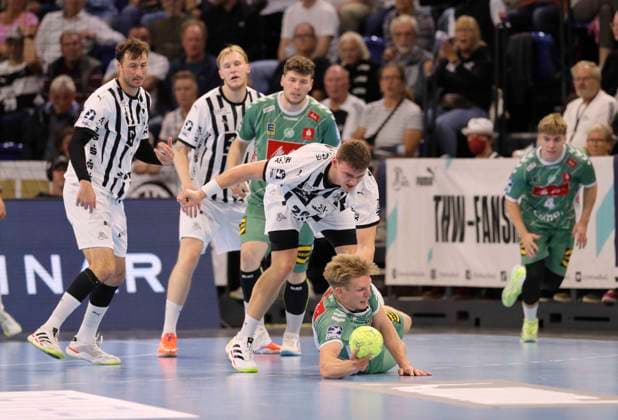 Foto : ein Hechter von ... Niclas Heitkamp ( Minden ) gegen Lukas Laube (Kiel) Handball Herren 1. Bundesliga am Do. 25.09.2025 THW Kiel - GWD Minden