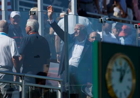 President Donald Trump waves to the crowd from behind a bulletproof glass wall as he arrives for the opening day of the 45th Ryder Cup at The Black Course at Bethpage State Park in Farmingdale, New York on Friday, September 26, 2025.  RYD20250926804 JOHNxANGELILLO
