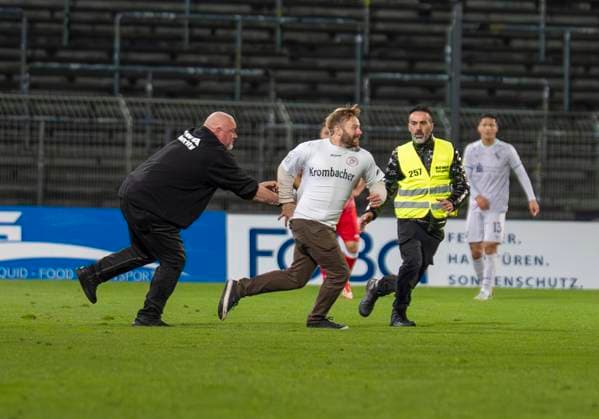 Flitzer im Leimbachstadion. Ordner versuchen den Flitzer einzufangen. Sportfreunde Siegen - VfL Bochum U21, U 21 26.09.2025 Fussball, Regionalliga West, 10. Spieltag, GER, Siegen, Leimbachstadion Siegen Copyright: HMBxMedia xMarcoxBader