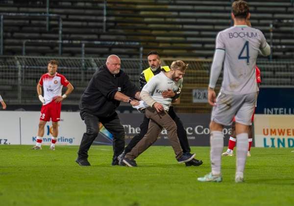 Flitzer im Leimbachstadion. Ordner versuchen den Flitzer einzufangen. Sportfreunde Siegen - VfL Bochum U21, U 21 26.09.2025 Fussball, Regionalliga West, 10. Spieltag, GER, Siegen, Leimbachstadion Siegen Copyright: HMBxMedia xMarcoxBader