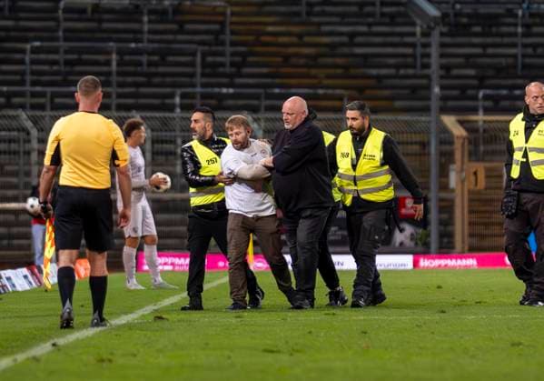 Flitzer im Leimbachstadion. Ordner haben den Flitzer geschnappt und begleiten ihn nach draußen. Sportfreunde Siegen - VfL Bochum U21, U 21 26.09.2025 Fussball, Regionalliga West, 10. Spieltag, GER, Siegen, Leimbachstadion Siegen Copyright: HMBxMedia xMarcoxBader