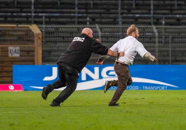 Flitzer im Leimbachstadion. Ordner versuchen den Flitzer einzufangen. Sportfreunde Siegen - VfL Bochum U21, U 21 26.09.2025 Fussball, Regionalliga West, 10. Spieltag, GER, Siegen, Leimbachstadion Siegen Copyright: HMBxMedia xMarcoxBader