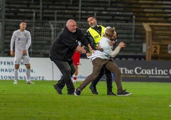 Flitzer im Leimbachstadion. Ordner versuchen den Flitzer einzufangen. Sportfreunde Siegen - VfL Bochum U21, U 21 26.09.2025 Fussball, Regionalliga West, 10. Spieltag, GER, Siegen, Leimbachstadion Siegen Copyright: HMBxMedia xMarcoxBader