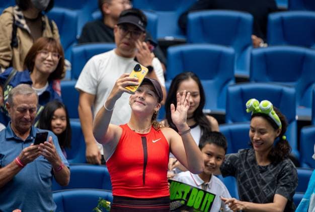 (250927) -- BEIJING, Sept. 27, 2025 -- Mirra Andreeva of Russia takes a selfie with fans after the women s singles second round match between Zhu Lin of China and Mirra Andreeva of Russia at 2025 China Open tennis tournament in Beijing, China, Sept. 27, 2025. ) (SP)CHINA-BEIJING-TENNIS-CHINA OPEN-WOMEN S SINGLES-SECOND ROUND (CN) HuxJingwen 