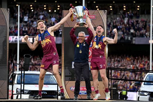 AFL GRAND FINAL, Harris Andrews and Lachie Neale of the Lions celebrate with head coach Chris Fagan (centre) folllowing their win in the AFL Grand Final between the Geelong Cats and the Brisbane Lions at the Melbourne Cricket Ground in Melbourne, Saturday, September 27, 2025. ( NO ARCHIVING, EDITORIAL USE ONLY MELBOURNE VICTORIA AUSTRALIA  Copyright: xJAMESxROSSx 20250927145546850670