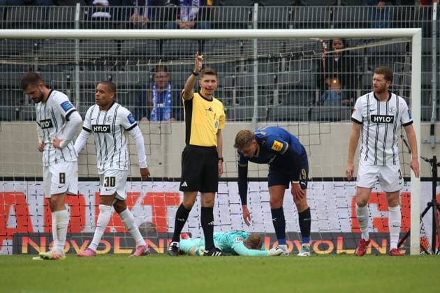 27.09.2025, xpfrx, Fussball 2.Bundesliga, SV Elversberg - Holstein Kiel v.l. Nicolas Kristof (SV Elversberg) verletzt, Verletzung, Schmerz, Schmerzen Phil Harres (Holstein Kiel) Schiedsrichter Referee Felix Wagner (DFL DFB REGULATIONS PROHIBIT ANY USE OF PHOTOGRAPHS as IMAGE SEQUENCES and or QUASI-VIDEO) Elversberg