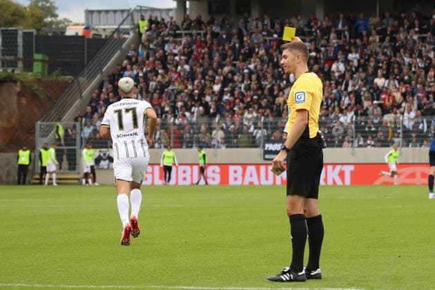 27.09.2025, xpfrx, Fussball 2.Bundesliga, SV Elversberg - Holstein Kiel v.l. Schiedsrichter Referee Felix Wagner zeigt Frederik Schmahl (SV Elversberg) die gelbe Karte (DFL DFB REGULATIONS PROHIBIT ANY USE OF PHOTOGRAPHS as IMAGE SEQUENCES and or QUASI-VIDEO) Elversberg