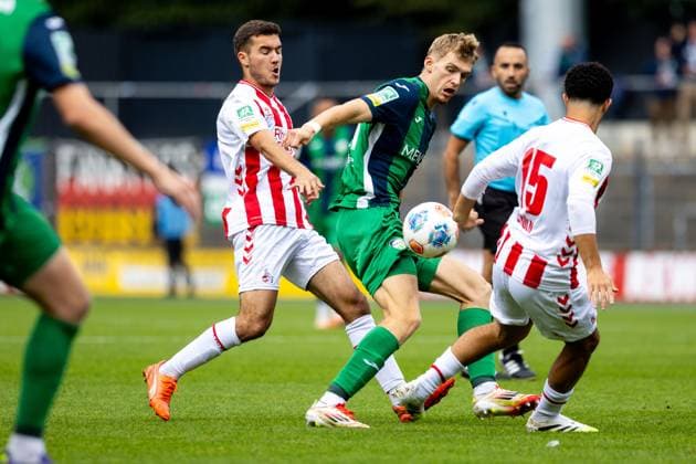 27.09.2025, xkwix, Fußball, Regionalliga West, 1. FC Köln U23 - FC Gütersloh, Geißbockheim Franz-Kremer-Stadion: Luis Frieling (FC Gütersloh 21) im Zweikampf gegen Fayssal Harchaoui (1. FC Köln U23 9) und Etienne Paul (1. FC Köln U23 16) NRW Deutschland