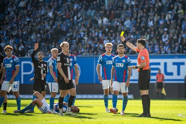 Rostock, Deutschland 27. September 2025: 3. Liga - 2025 2026 - FC Hansa Rostock vs. TSV Havelse Im Bild: 1.v.re. Schiedsrichter Justin Hasmann zeigt Gelb, gelbe Karte, 4.v.li. Johann Berger (TSV Havelse) DFB regulations prohibit any use of photographs as image sequences and or quasi-video. Copyright: xFotostandx xVoelkerx
